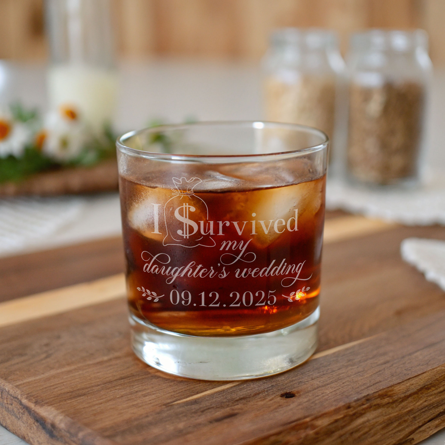Glass of iced drink with 'I Survived my daughter's wedding' text on a wooden surface