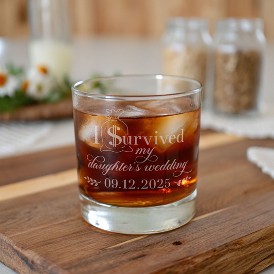 Glass of iced drink with 'I Survived my daughter's wedding' text on a wooden surface